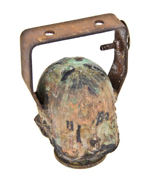 heavily coated vintage american industrial hollow copper doll head mold or form with stationary bent steel mounting bracket 