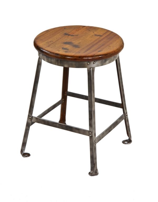 diminutive early 1930's american vintage industrial four-legged riveted joint angled steel factory stool with nicely weathered mahogany wood seat