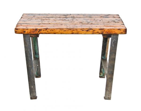 unique world war ii-era american vintage industrial munitions plant or factory workbench with heavy cast iron legs and thick old growth pine wood plank tabletop