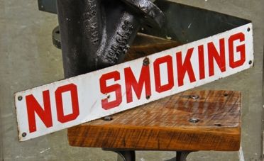 early american c. 1940's single-sided industrial white porcelain enameled die cut steel "no smoking" factory sign with intact grommets