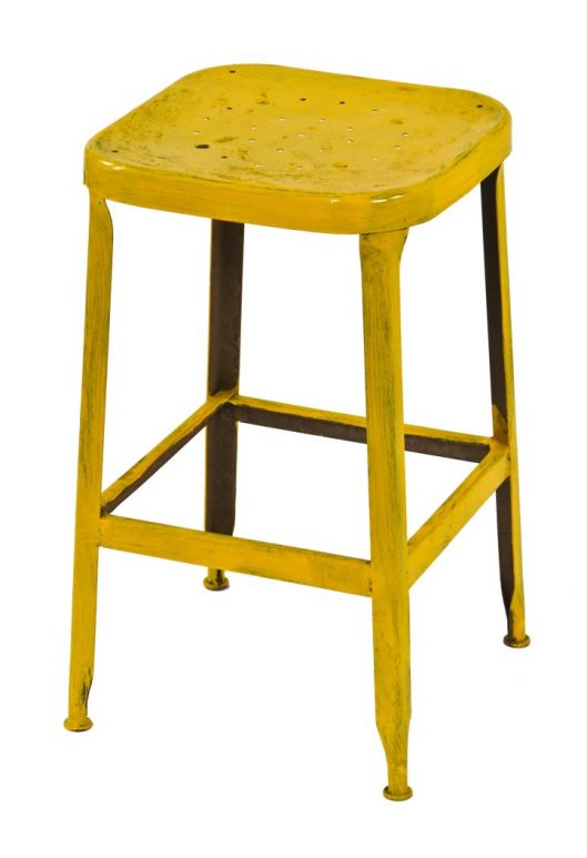c. 1950's original yellow painted four-legged american industrial pressed and folded steel low-lying stool with a ventilated seat