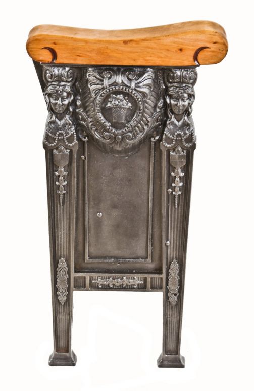 refinished original c. 1920's freestanding heavily ornamented cast iron theater seat end with slid birch wood set rest and opposed female faces with flowing hair