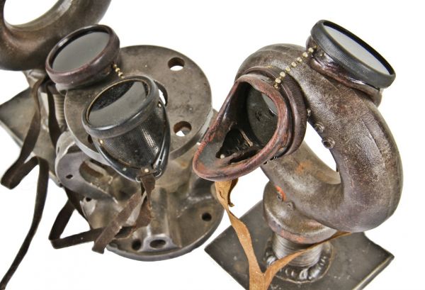 two matching antique american industrial "durasteel" steampunk welding goggles with head straps and enameled steel baffled side shields for ventilation purposes