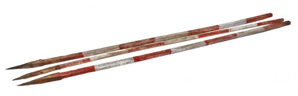 set of three identical depression era american industrial weathered and worn land surveying range poles with alternating white and red painted stripes 