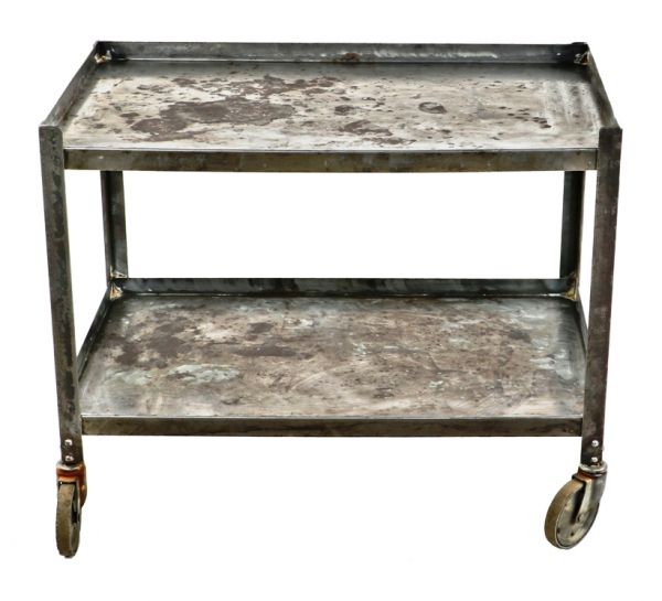 intact and refinished c. 1930's american antique industrial pressed and folded riveted joint steel two tier mobile albert pick hospital cart with a mostly uniform brushed metal finish