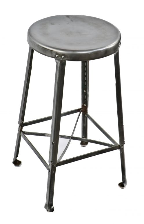 fully refinished antique american industrial robust heavy gauge steel all-riveted joint factory machinist stool with distinctive inward-turned ball feet 
