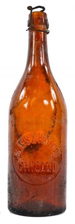 very rare and all original antique late 19th century richly colored amber quart bottle with circular-shaped slug plate manufactured for chicago bottler blass & hofelot