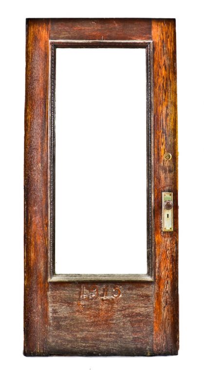 late 19th century original and intact varnished oak wood chicago residential entrance door with hardware and oversized plate glass pane with beveled edges