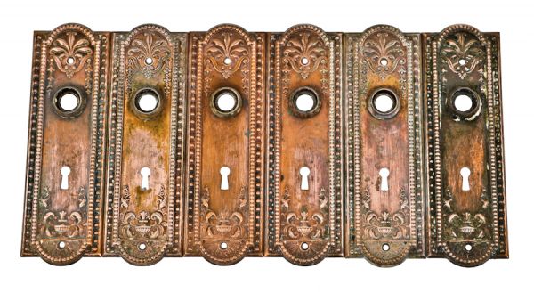 three set of original c. 1910 antique american interior residential "como" pattern ornamental metal doorknob escutcheons with nicely aged copper-plated finish