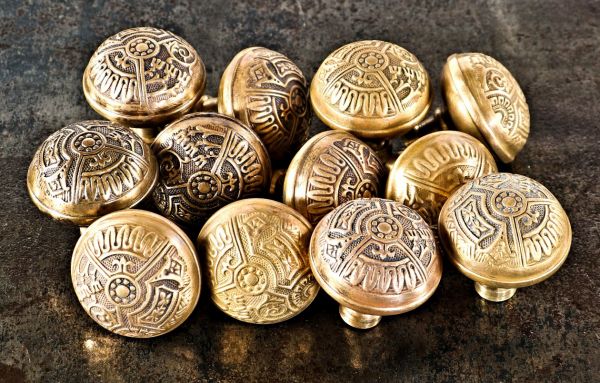 twelve matching highly sought after all original late 19th century american eastlake style "ceylon" pattern wrought brass dome-shaped doorknobs with banded rims 