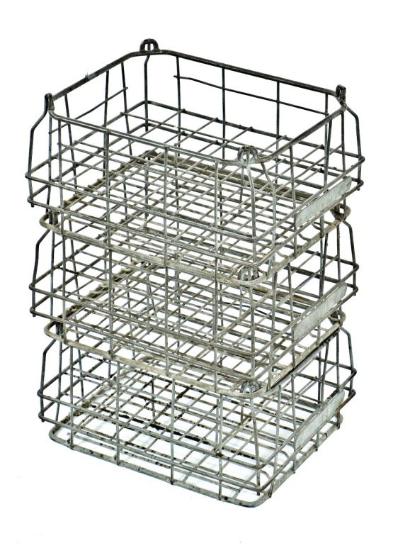 group of three matching american depression era reinforced industrial bent steel milk and/or dairy stackable storage crates with stamped steel identification tags
