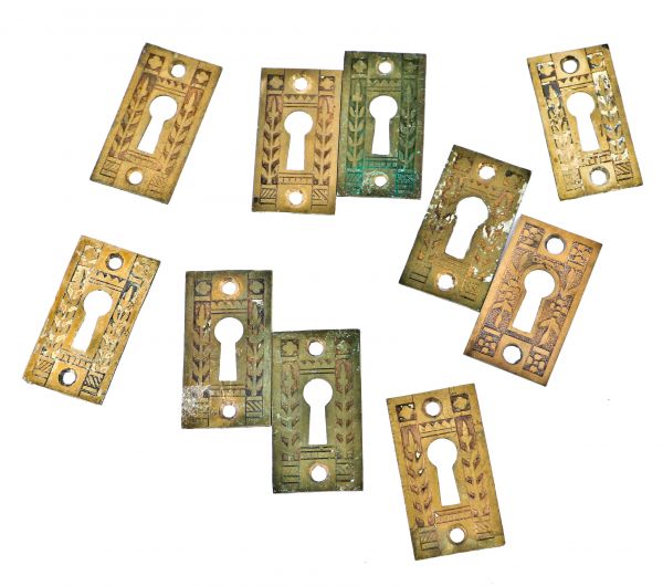 group of all original 19th century antique american ornamental cast brass interior residential keyhole escutcheons replete with floral motifs flanking the single keyholes