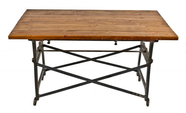 fully functional and intact antique american industrial repurposed oversized mobile shop table supported by "medart" cast iron workbench legs or bases 