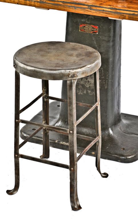 late 1920's antique american industrial brushed and sealed riveted joint angled steel factory machine shop stool with flared feet and channeled legs