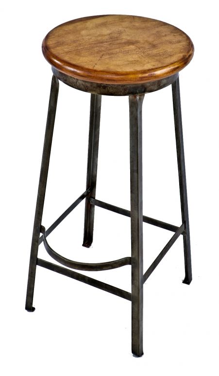 single depression era american industrial refinished riveted joint four-legged angled steel stationary stool with original solid maple wood seat and protruding footrest 