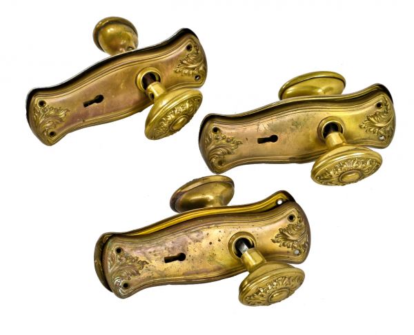 three complete sets of early 20th century antique american stamped brass ornamental interior residential doorknobs and matching backplates 