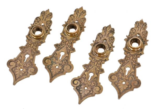 group of four original antique american ornamental cast bronze 1870's victorian era doorknob backplates with pronounced thimbles and single keyholes