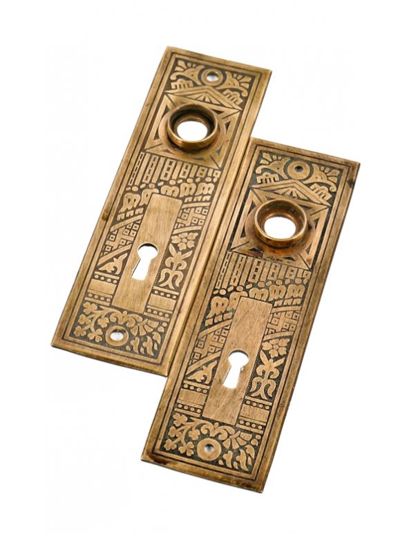 two matching original and intact ornamental american eastlake style heavy stamped brass "ceylon" pattern residential doorknob backplates