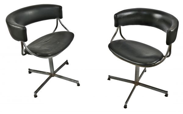 pair of jansko stationary mid-century modern interior residential swivel chairs upholstered in soft black faux leather with interesting backrest detail and original rubberized protective feet