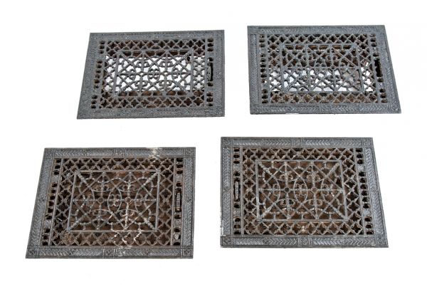 group of four matching intricately designed ornamental cast iron 19th century salvaged chicago louvered floor grates or registers with black enameled finish 