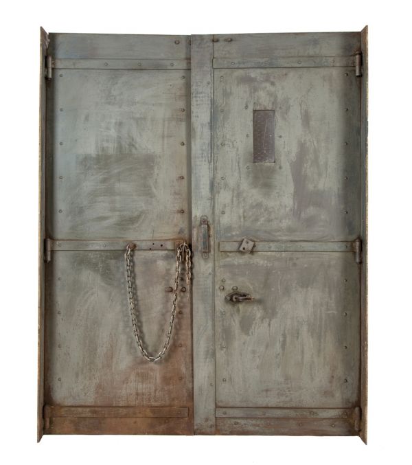 two interlocking early 20th century heavy gauge steel salvaged chicago factory building freestanding elevator doors with diminutive portal containing chicken wire glass 