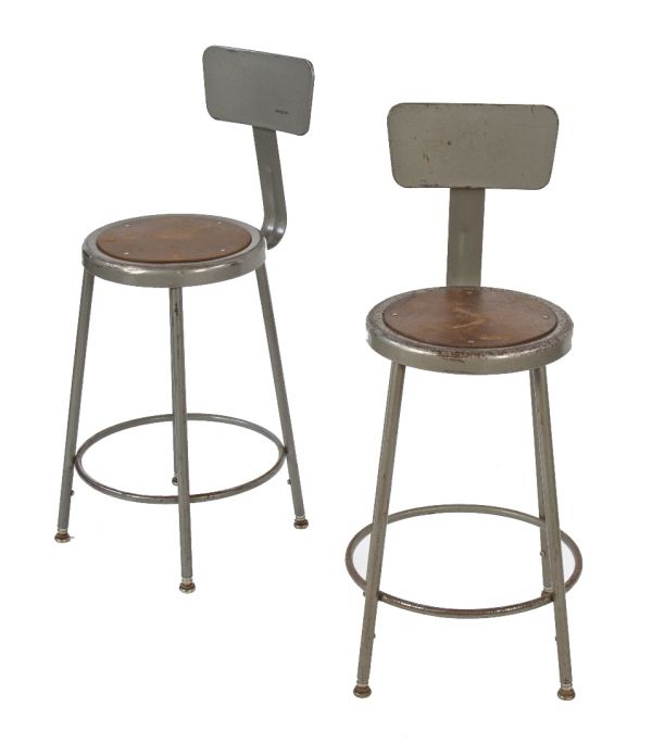 two matching c. 1960's vintage american industrial adjustable height factory shop stools with leg extensions and intact "gunship" gray enameled finish 