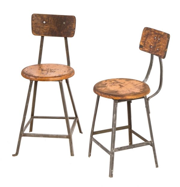 two 1920's original riveted joint angled steel four-legged factory machine shop stationary stools with intact solid maple wood seats and contoured backrests