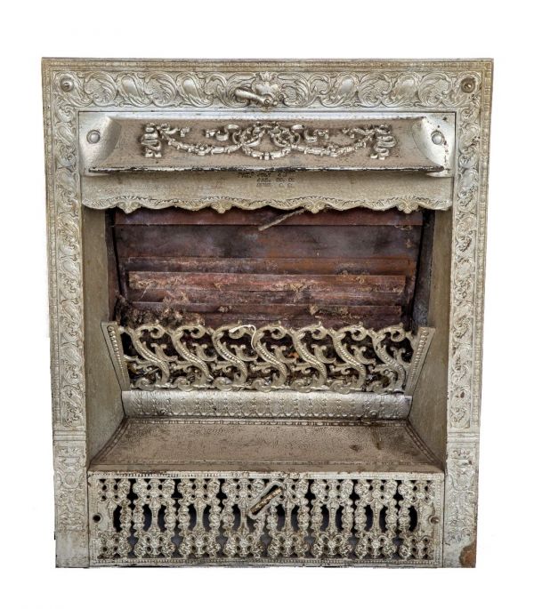 single 19th century original and intact ornamental cast iron interior residential gas fireplace insert with protruding hood and perforated grill 