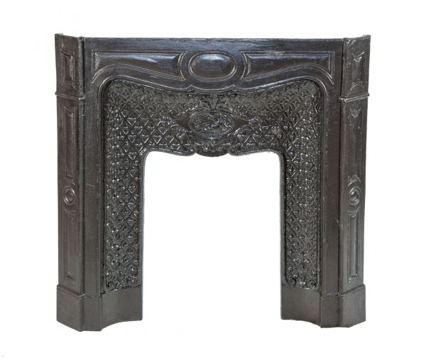 late 19th or early 20th century salvaged ornamental cast iron interior hotel building fireplace mantel with centrally located winged cherub 