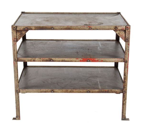 oversized vintage american industrial four-legged angled steel stationary factory shelving unit with slightly raised edges 