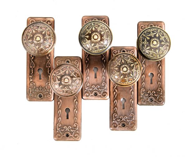 group of matching early 20th century wrought ornamental brass residential passage door backplates and doorknobs