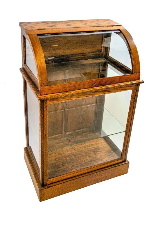 original 19th or early 20th century refinished oak wood freestranding display case with bent glass top and bottom cabinet with shelf