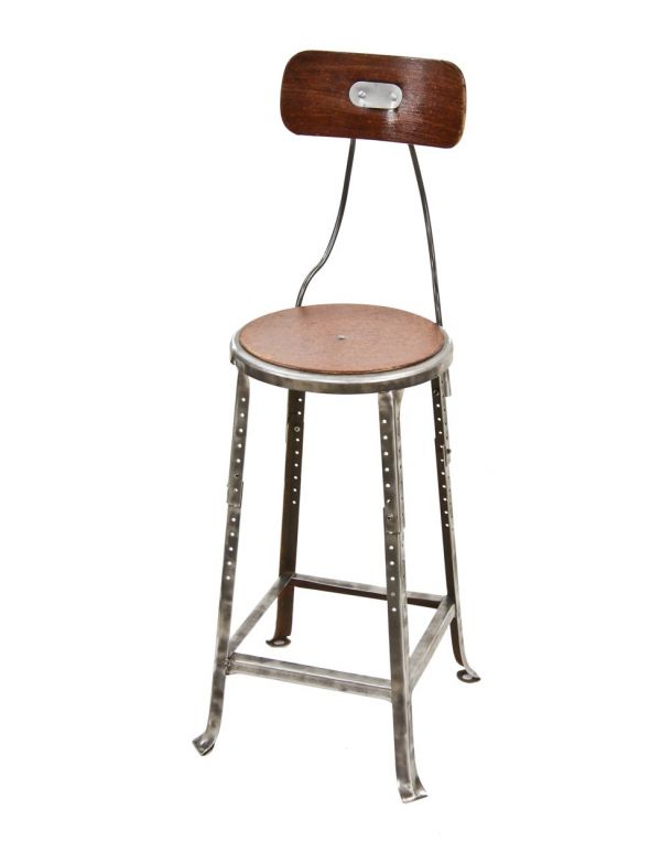 sturdy c. 1930's heavy gauge cold-rolled steel four-legged angled steel adjustable height factory stool with contoured maple wood backrest