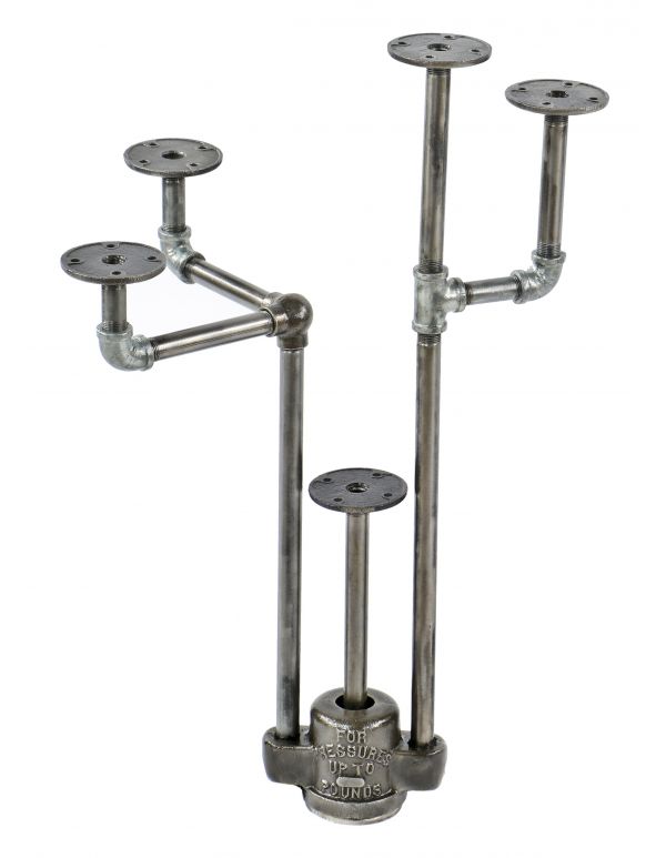 repurposed vintage american industrial object display stand with weighted boylston cast iron grease trap valve cover and old crane plumbing pipe fittings 