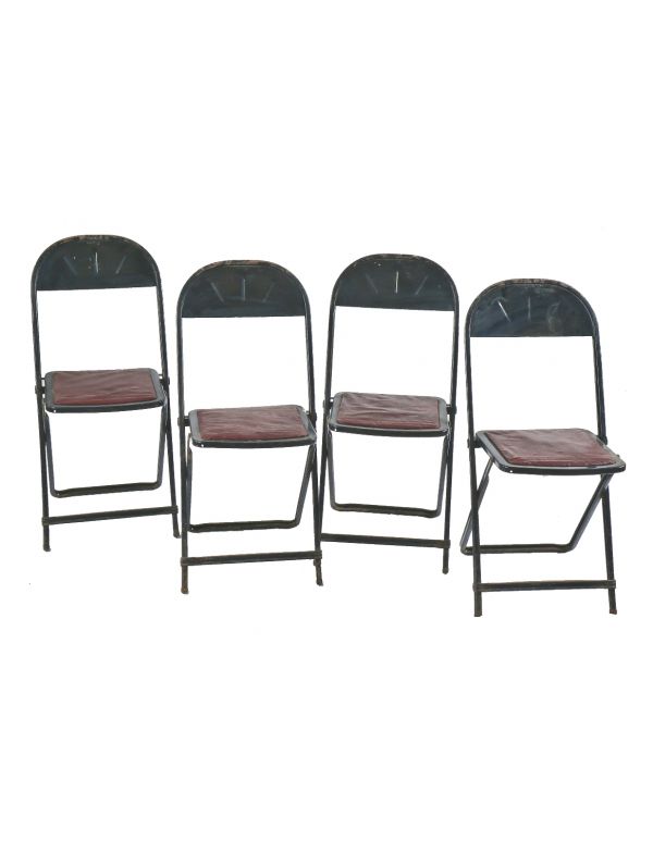 group of four matching heavily reinforced pressed and folded black enameled chicago stadium industrial folding chairs with original seat pads