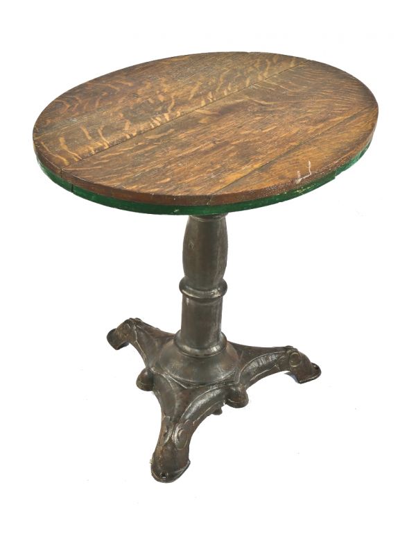 refinished late 19th century antique american stationary saloon table with brushed metal three-legged cast iron ornamental base and quarter-sawn oak wood top 