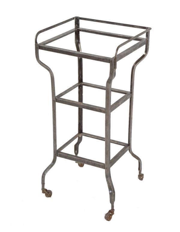 fully functional three-tier brushed metal antique american medical mobile hospital operating room cart or supply stand with intact swivel casters and glass plate shelves 