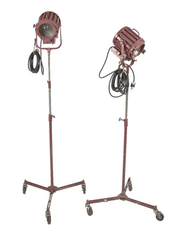two matching vintage american industrial fully adjustable studio stage set spotlights with three-legged mobiles stands 