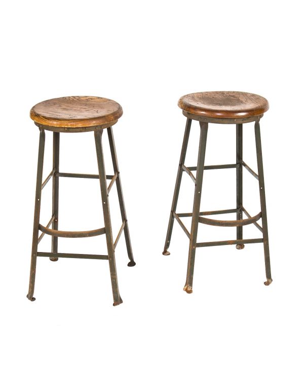 two matching vintage american industrial angled steel dietzgen stools with solid maple wood seats and foot rests