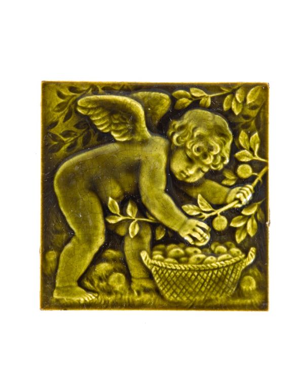 19th century original vividly-colored green majolica-glazed figural tile featuring cherub or putti with fruit basket