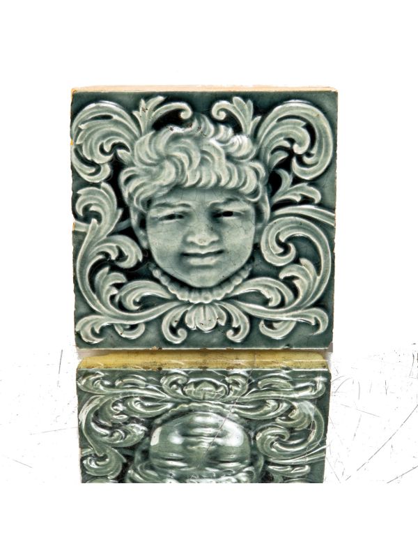 late 19th century original 6 x 6 inch majolica-glazed trent figural fireplace tile featuring centrally located face surrounded by foliage 