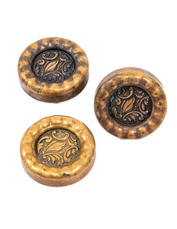 group of matching early 20th century wrought ornamental bronze "eulalia" pattern doorknobs with sunken centers