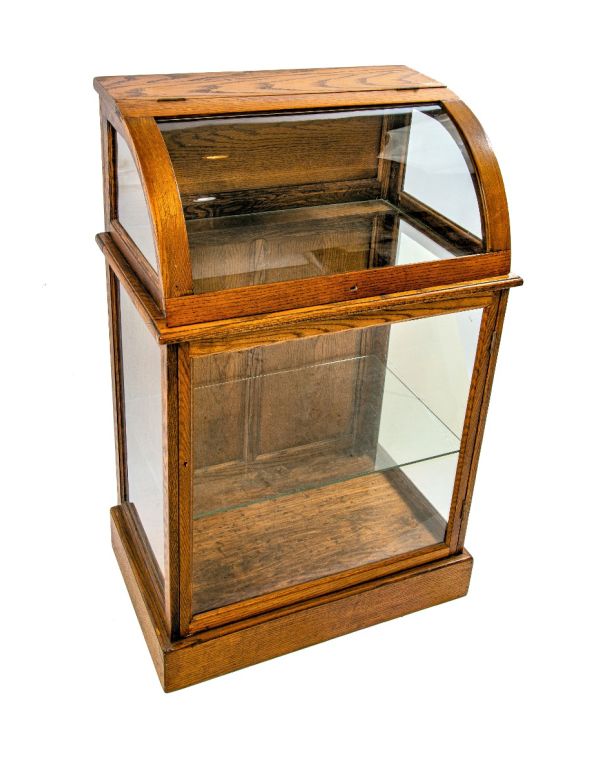 original 19th or early 20th century refinished oak wood freestranding display case with bent glass top and bottom cabinet with shelf
