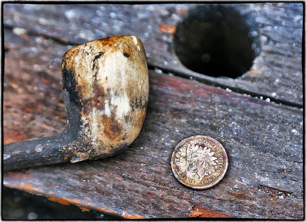 a clay pipe and civil war-era indian head penny discovered in the privy 