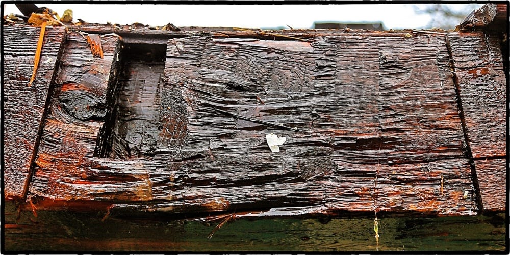 detail of horizontal framing timber containing a hand-hewn section (shaped with an adze)