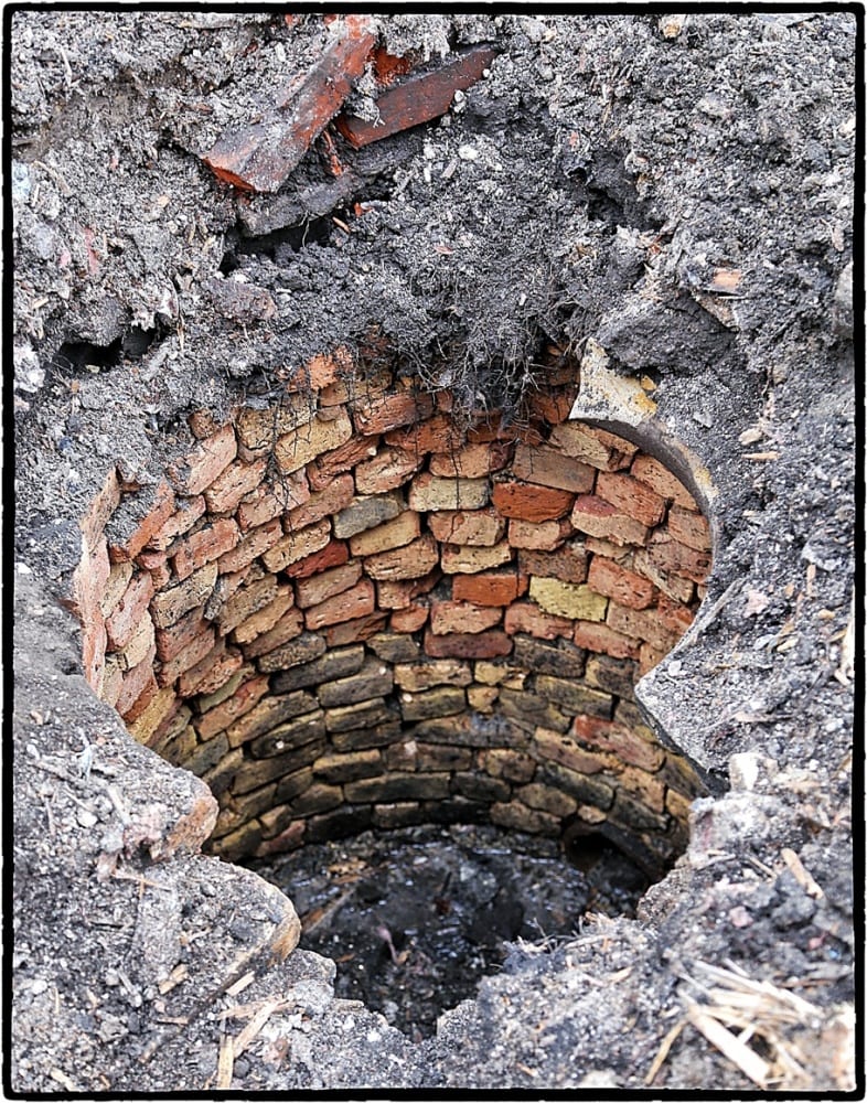 the residential brick-lined privy exposed after the limestone and cast iron cover were removed.